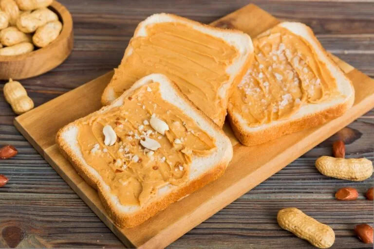 Persona unta mantequilla de maní en pan integral como parte de una dieta equilibrada y saludable.
