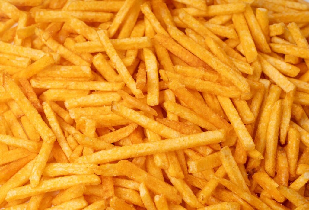 Fotografía editorial de papas fritas con referencia a su impacto en hipertensión y salud cardiovascular