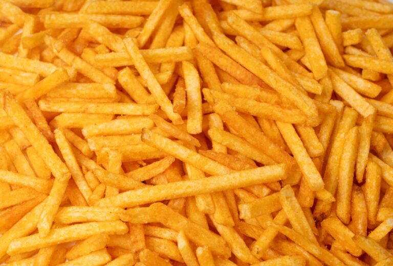 Fotografía editorial de papas fritas con referencia a su impacto en hipertensión y salud cardiovascular