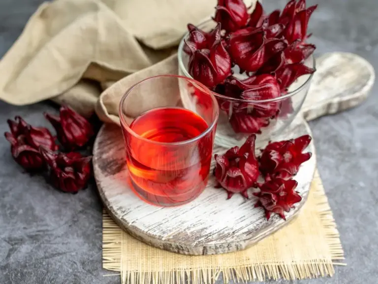 Vaso con agua de Jamaica clara, natural, preparado sin azúcar para promover salud cardiovascular y metabólica