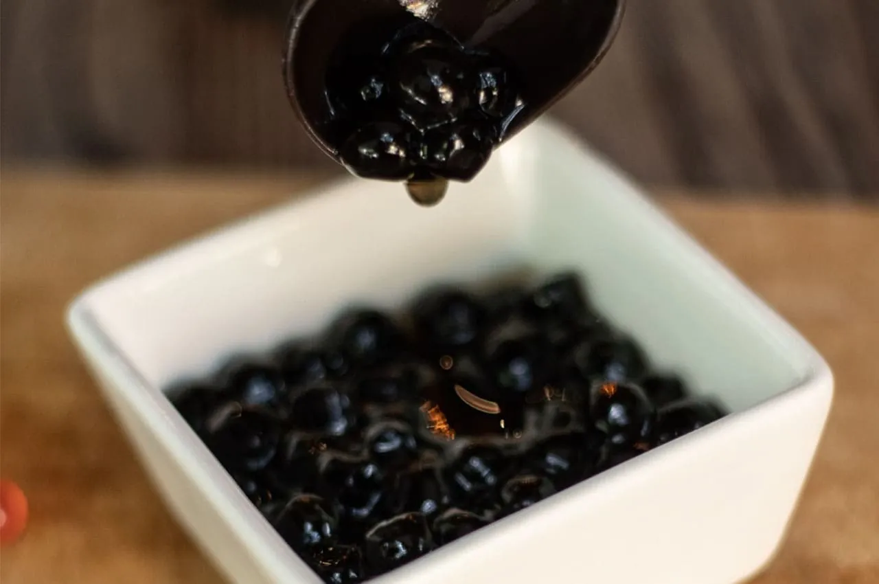 Beneficios de la tapioca mostrados en perlas frescas junto a frutas en una bebida tipo bubble tea