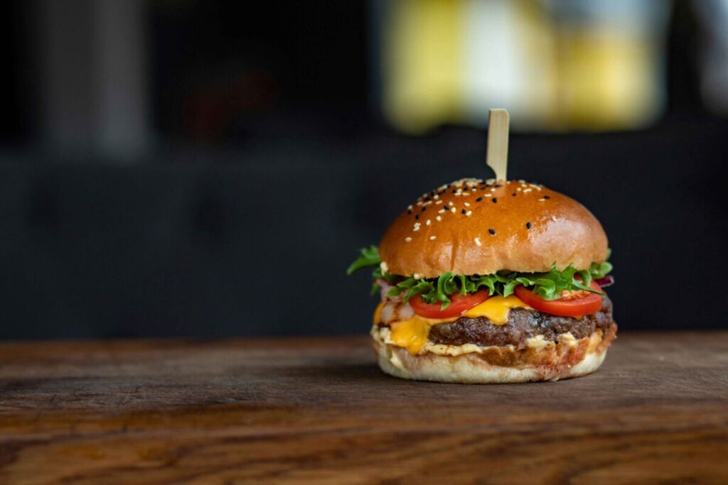 Persona en España comiendo hamburguesa de noche, reflejo del impacto en sueño y metabolismo