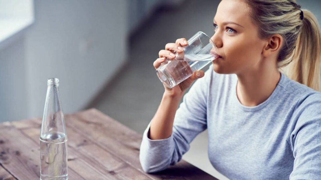 Personas de diferentes edades bebiendo agua para reflejar la ingesta de agua diaria recomendada