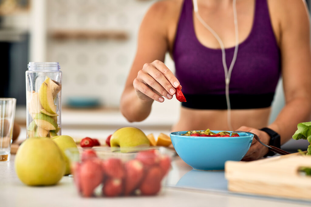 Personas felices hidratándose y comiendo alimentos ricos en fibra para cuidar la salud digestiva
