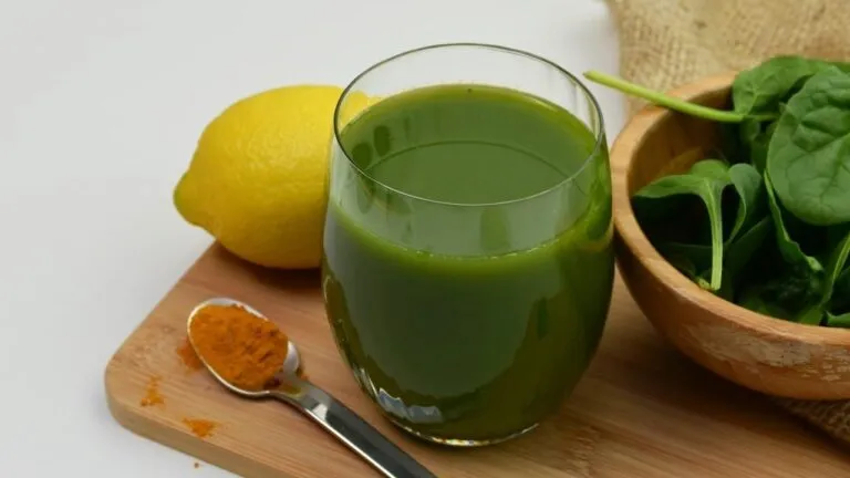 Foto editorial de jugo verde fresco y cúrcuma para nutrición antiinflamatoria y energética