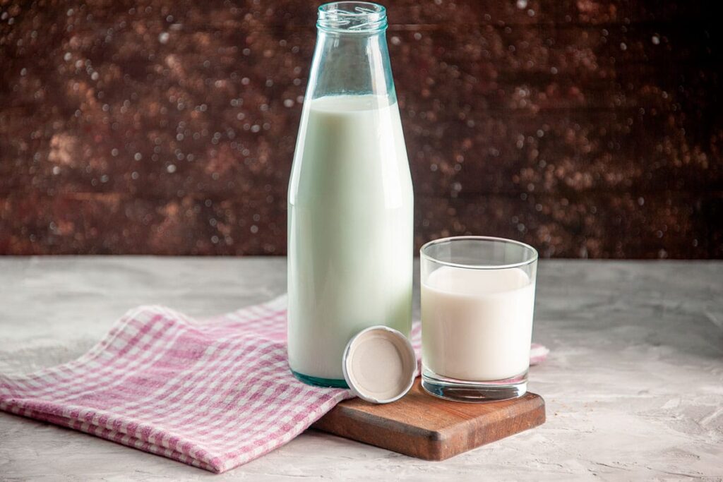 Impacto nutricional de la leche mostrado en un vaso de leche junto a frutas y cereales saludables
