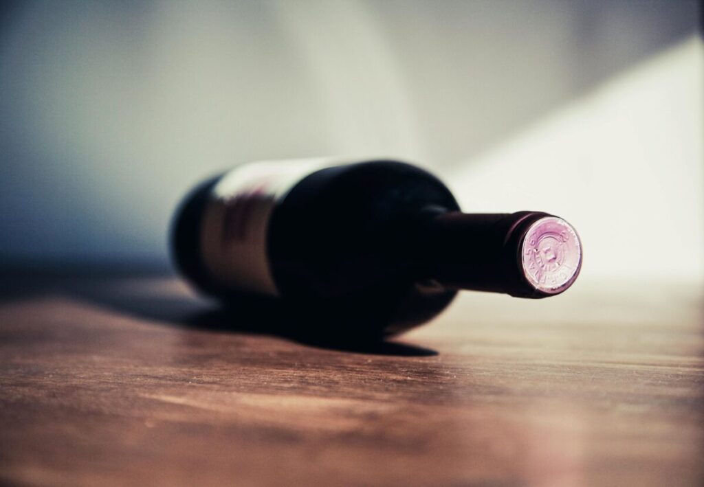 Imagen de una copa de vino sobre una mesa con luz natural, resaltando la moderación y salud hepática