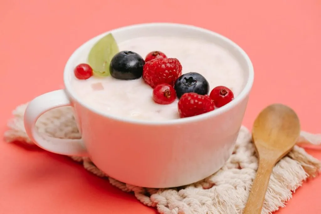 Cuenco de yogur natural con frutas frescas, representando una opción saludable rica en proteína