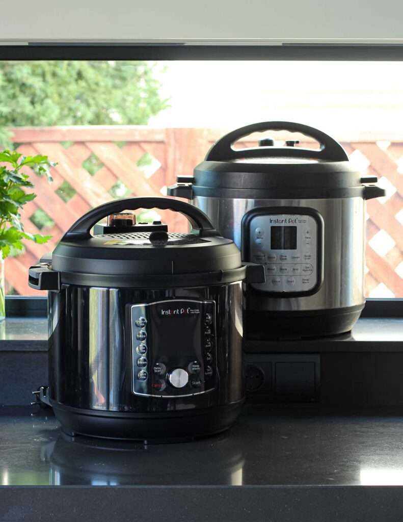 Olla Instant Pot sobre una mesa rodeada de ingredientes frescos