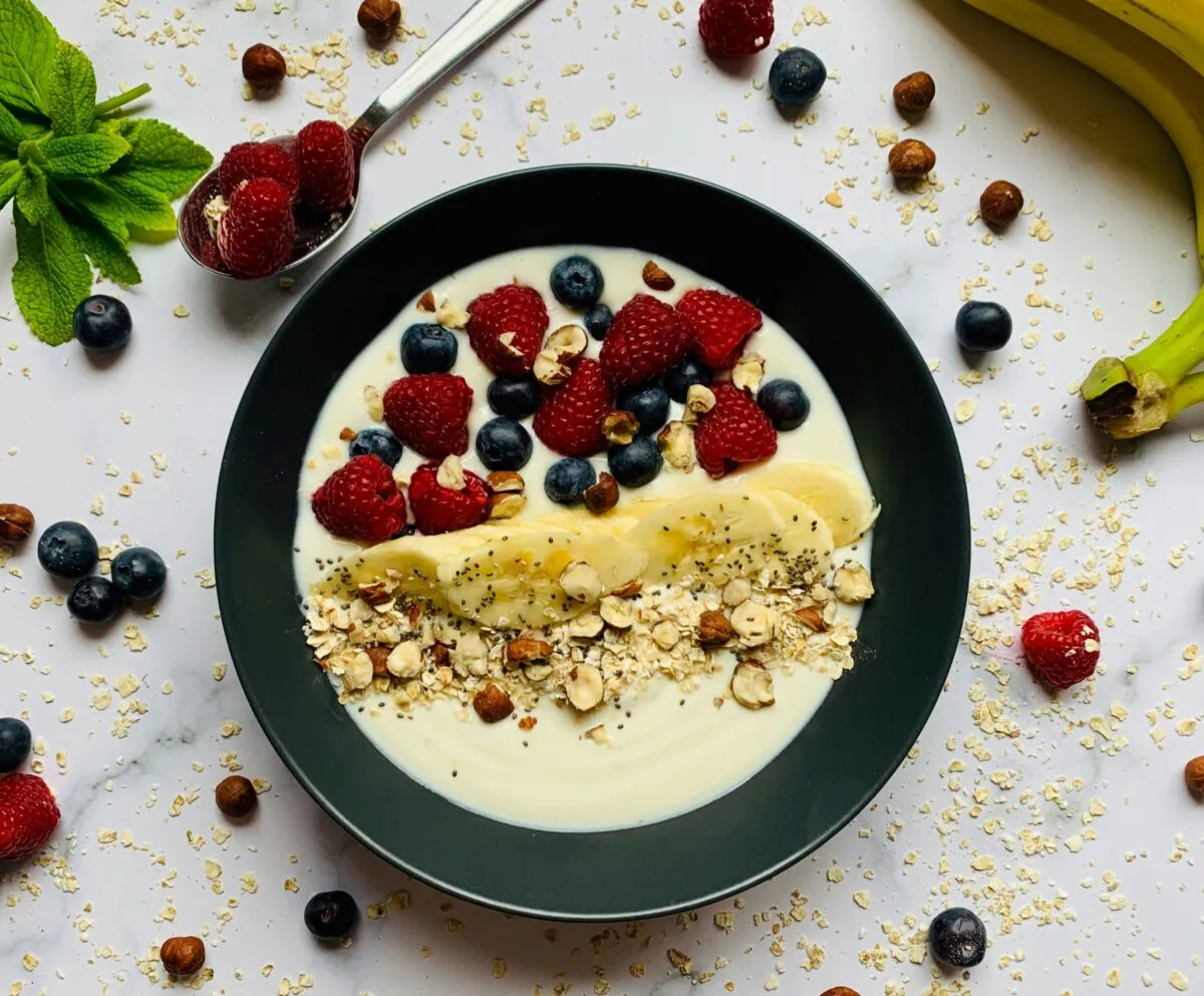 Fotografía de un desayuno saludable con frutas, yogur y avena que muestra desayunos con pocas calorías para energía matutina.