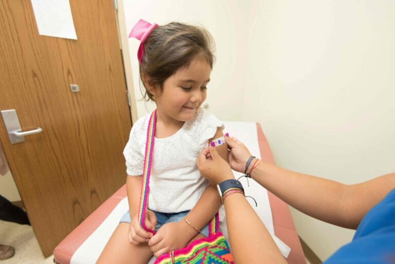 Niña recibiendo vacuna para prevenir la polio en centro de salud, protección contra enfermedades infecciosas