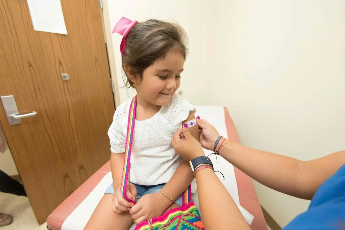 Niña recibiendo vacuna para prevenir la polio en centro de salud, protección contra enfermedades infecciosas