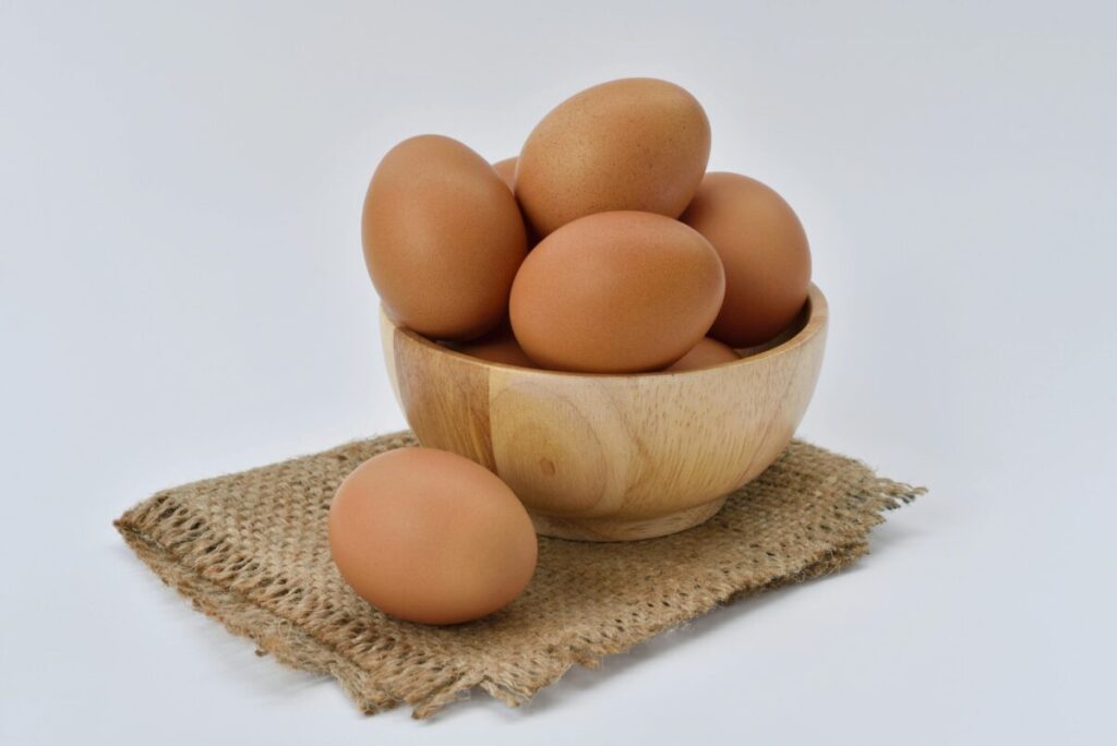 Fotografía editorial de huevos frescos en una cocina moderna, simbolizando alimento saciante que ayuda a controlar el apetito y fortalecer músculos