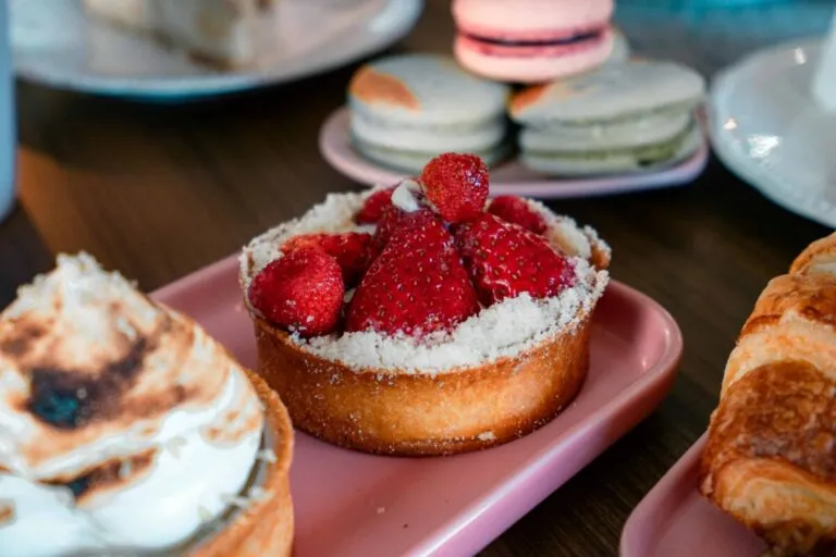 Persona eligiendo frutas frescas en lugar de postres azucarados para mejorar la salud y reducir el exceso de azúcar