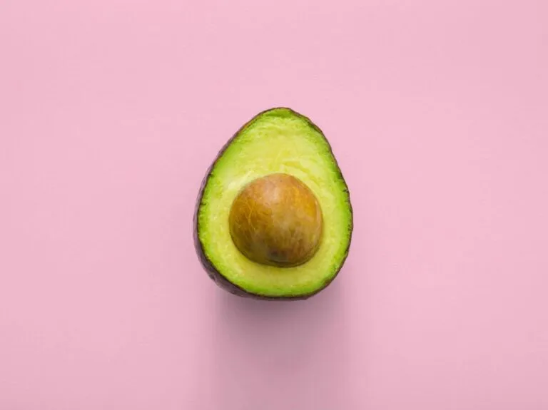Persona cortando un aguacate en una cocina moderna con luz natural