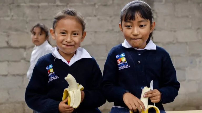Niños mexicanos comiendo frutas y verduras en la escuela tras la regulación de alimentos ultraprocesados