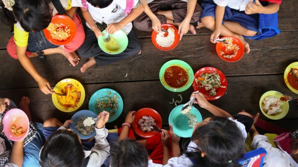 Manos sosteniendo frutas y verduras frescas que representan los esfuerzos de México hacia el objetivo Hambre Cero
