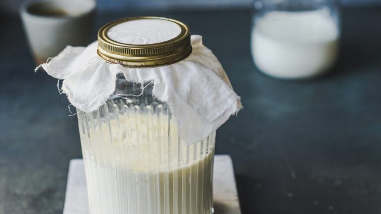 Vaso de kéfir natural rico en probióticos que mejora la digestión y reduce el colesterol dentro de una dieta saludable