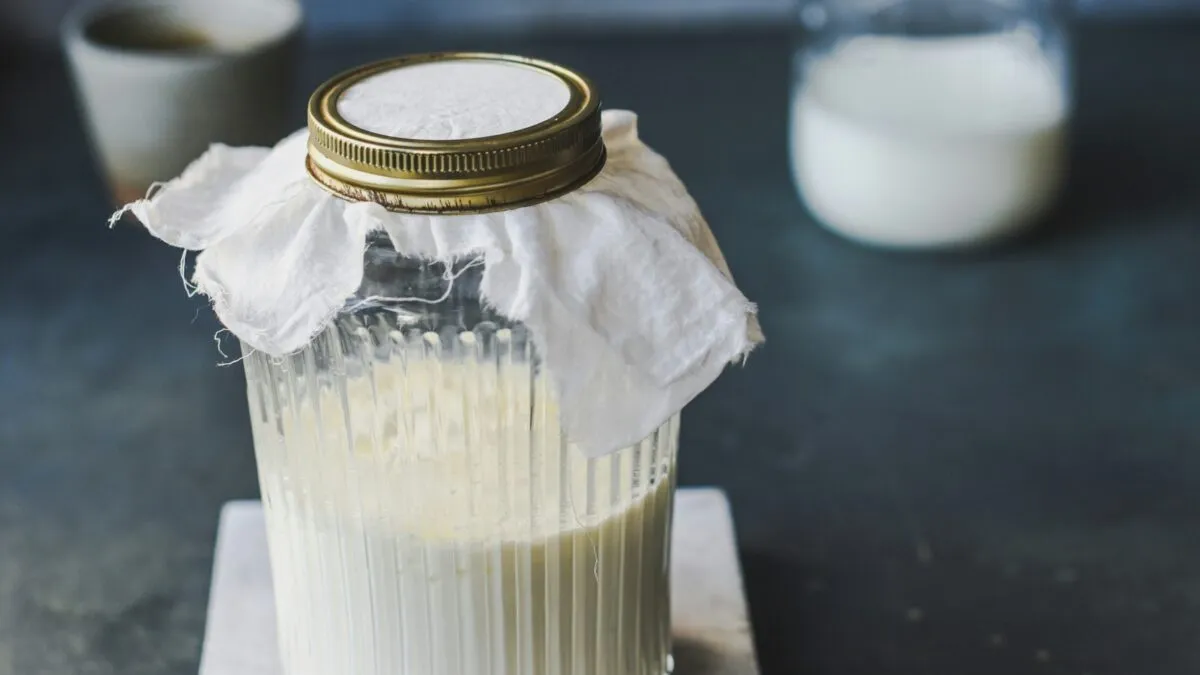 Vaso de kéfir natural rico en probióticos que mejora la digestión y reduce el colesterol dentro de una dieta saludable