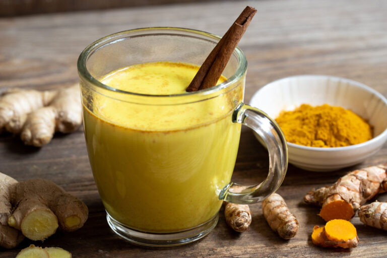 Taza con golden milk dorada preparada con cúrcuma, jengibre y canela para fortalecer el sistema inmunitario y relajarse antes de dormir.