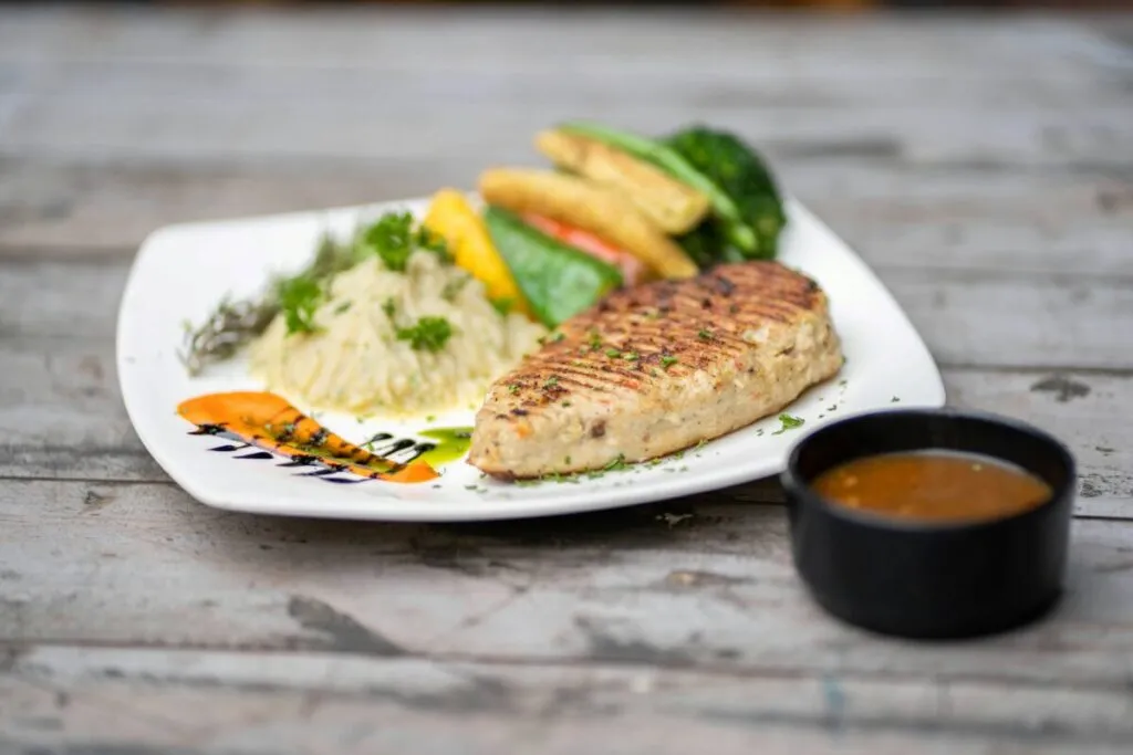 Plato de pescado blanco con vegetales ideal para cenar y mejorar el sueño
