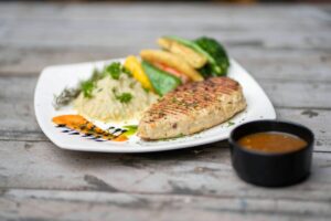 Plato de pescado blanco con vegetales ideal para cenar y mejorar el sueño