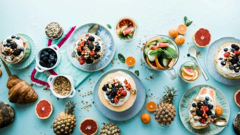 Mesa con alimentos saludables como chocolate negro, plátano, arándanos y té verde, ideales para mantener energía y concentración