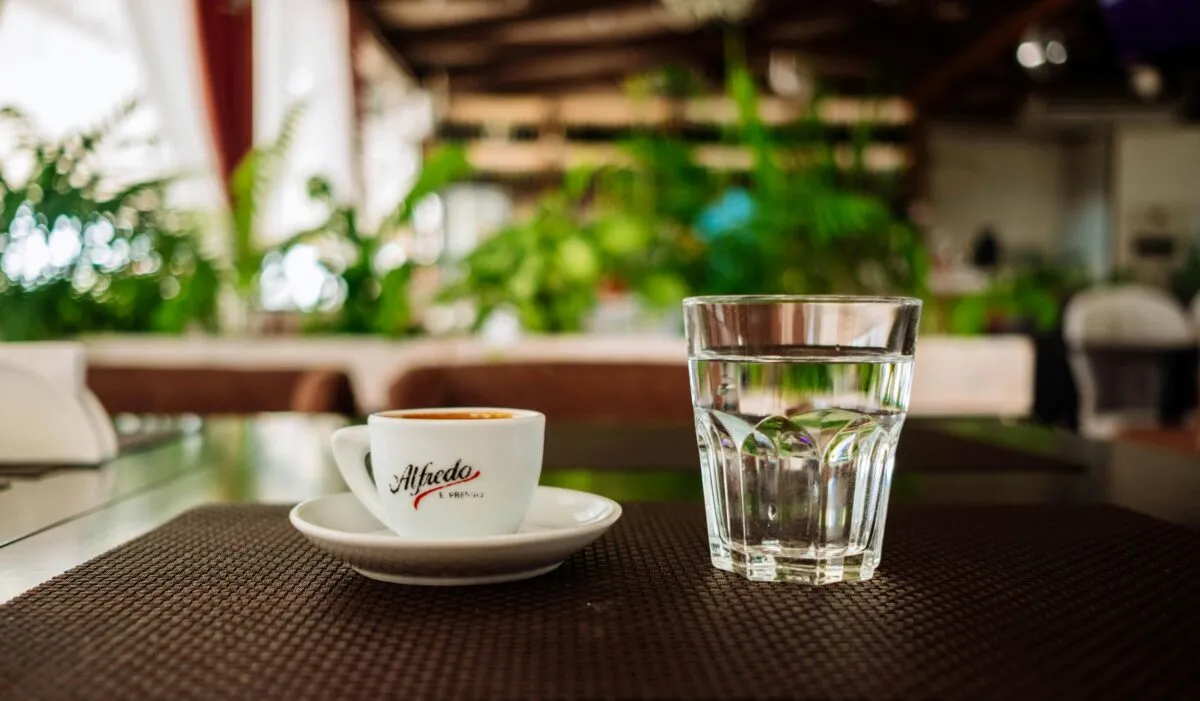 Fotografía editorial de un vaso con agua gratis servido en un restaurante en Perú, estilo limpio y profesional, simbolizando hidratación y hábitos saludables.
