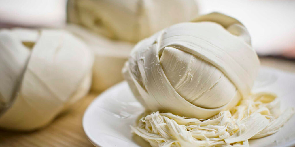 Variedad de quesos saludables acompañados de frutas y semillas que muestran una opción nutritiva y balanceada