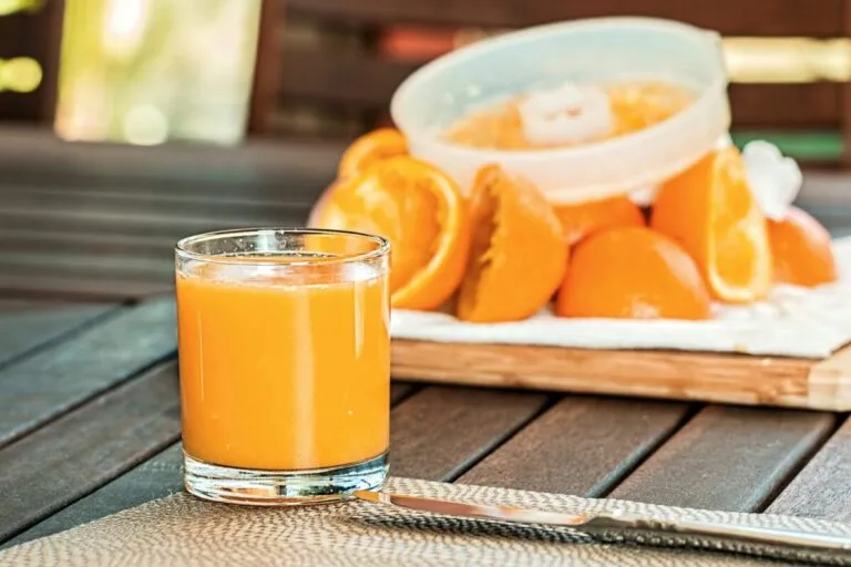 Mujer disfrutando un desayuno saludable con zumo de naranja natural en la mesa