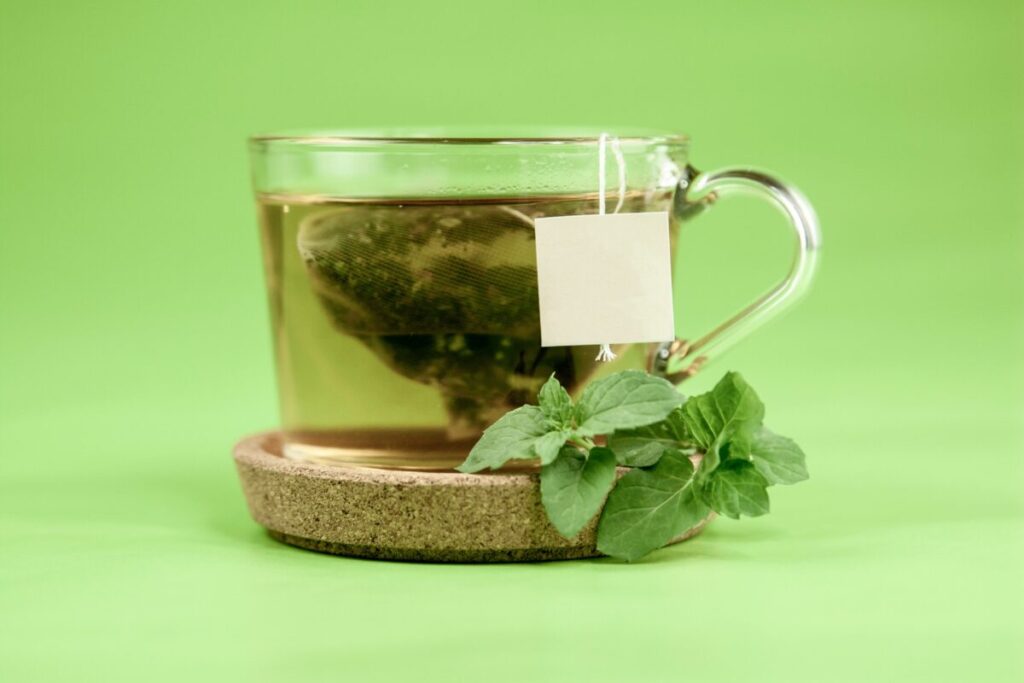 Té verde en taza de cerámica rodeada de ingredientes naturales que benefician el metabolismo y la microbiota intestinal