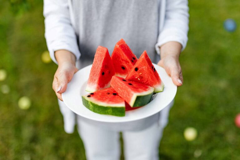 Mujer disfrutando sandía para bajar de peso, con fondo fresco y natural