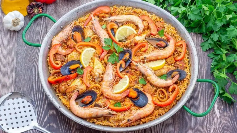 Paella saludable preparada con arroz, verduras frescas y aceite de oliva, ejemplo de equilibrio nutricional en la cocina tradicional.