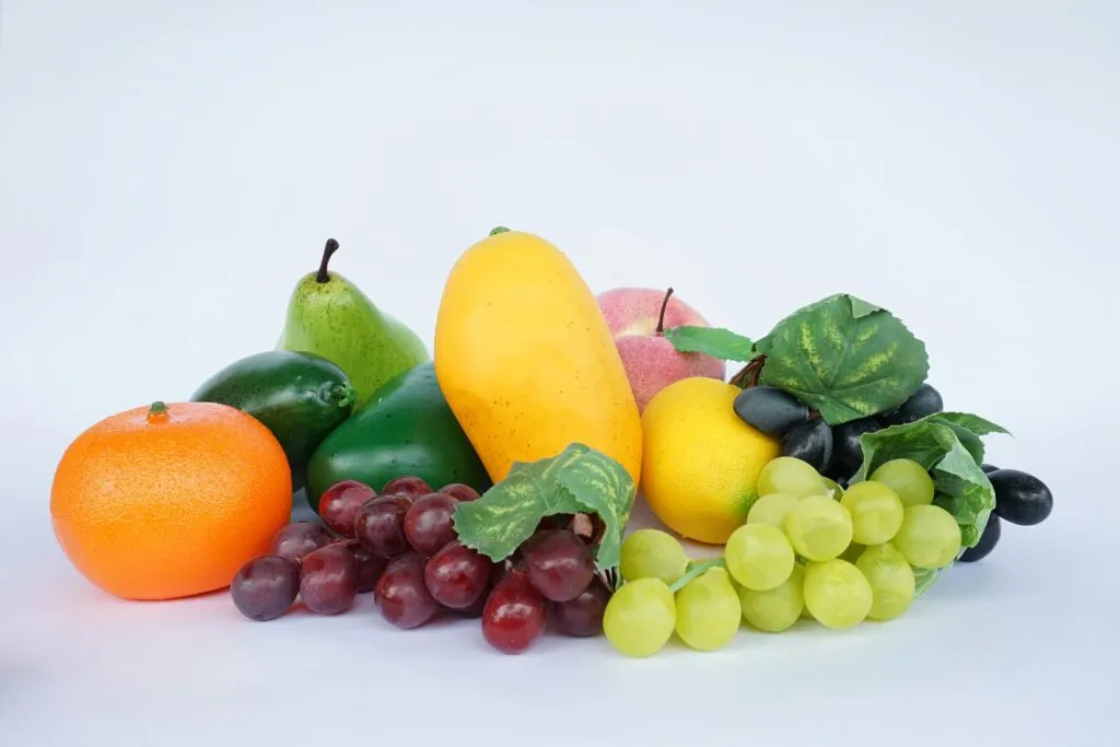 Frutas y verduras frescas con piel sobre una tabla de cocina, resaltando su contenido en fibra y antioxidantes