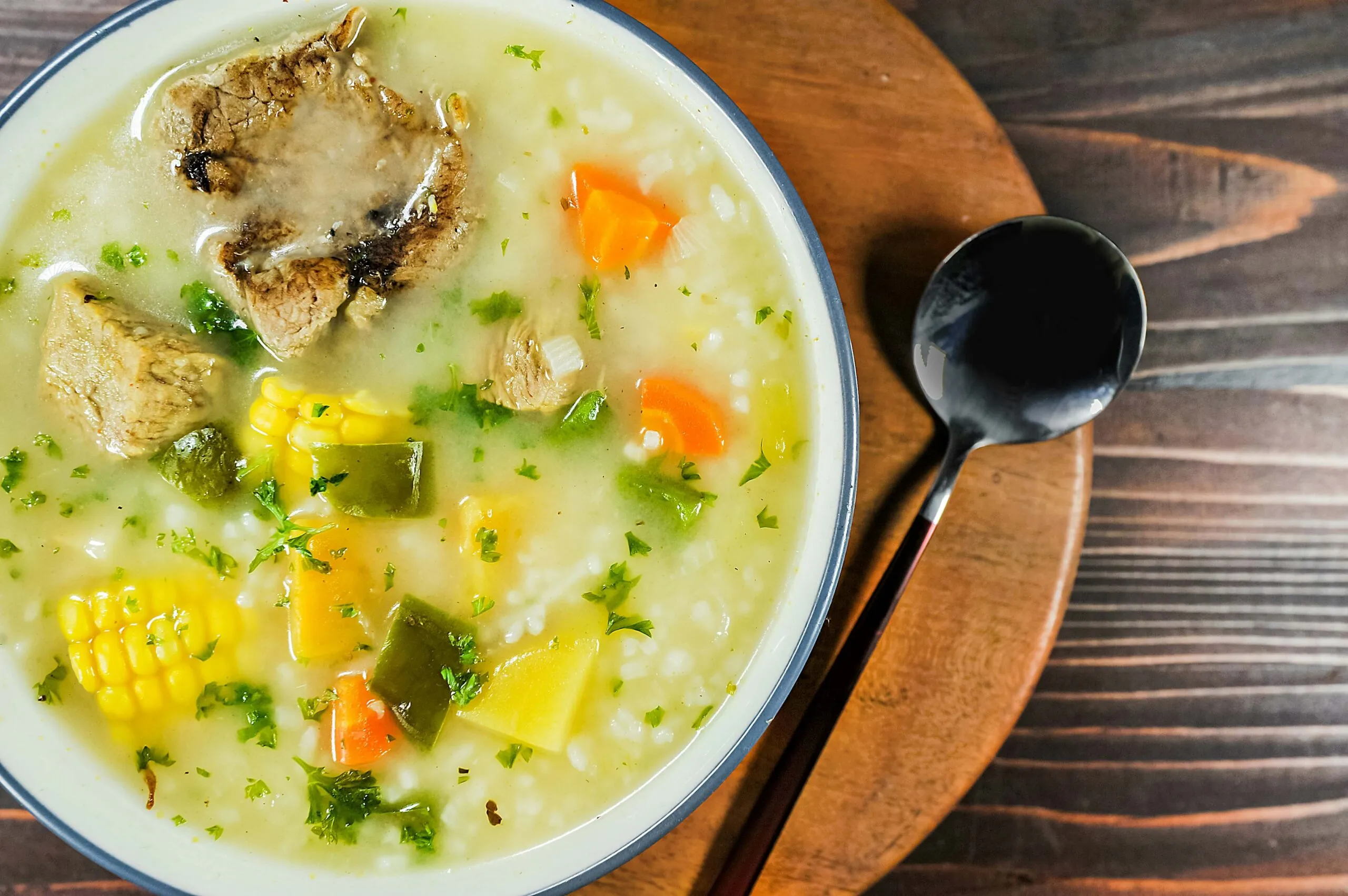 Tazón con sopa de verduras casera humeante, ideal para el invierno, sobre fondo cálido