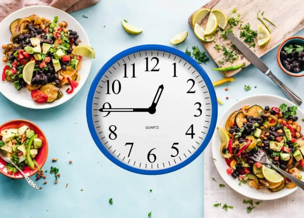 Reloj y alimentos saludables que representan la importancia de respetar horarios de comida para apoyar la salud metabólica