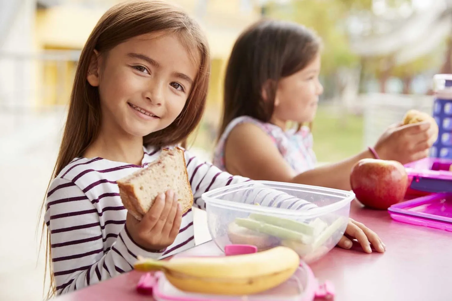 Estudiantes comiendo frutas y alimentos saludables en comedor escolar como parte de políticas de alimentación saludable en escuelas.
