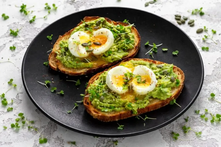 Plato con cuatro huevos al día acompañado de verduras, mostrando beneficios nutricionales para salud y saciedad