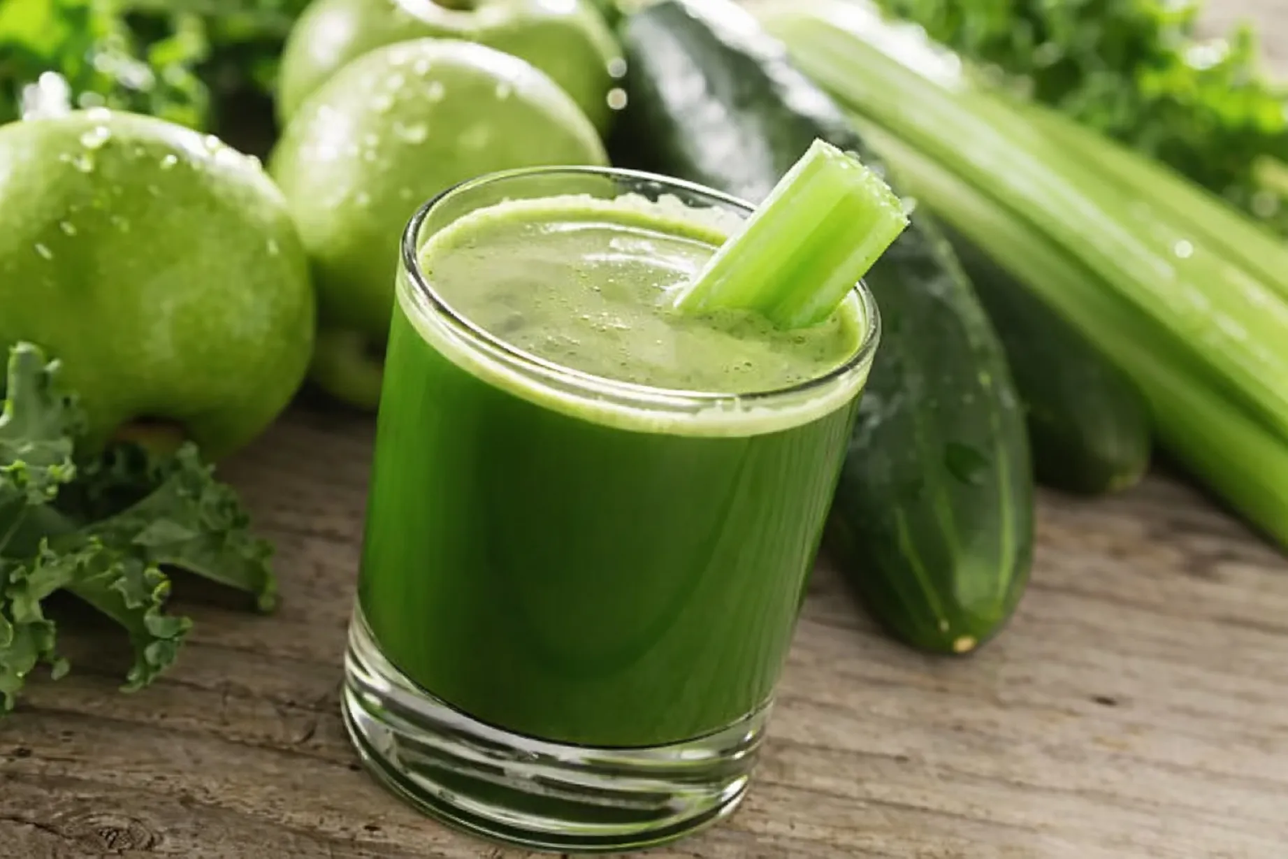 Vaso de jugo verde desayuno con verduras frescas que aporta vitaminas y antioxidantes en una dieta saludable