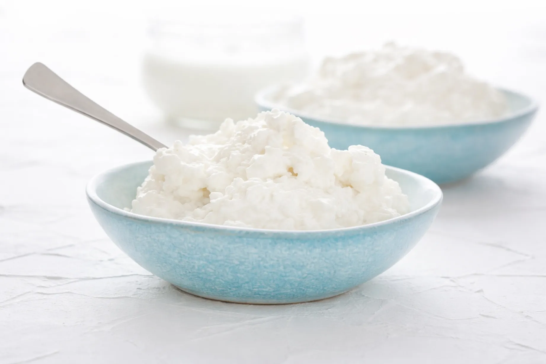 Queso cottage en bowl con frutas frescas y nueces, ideal para una alimentación saludable