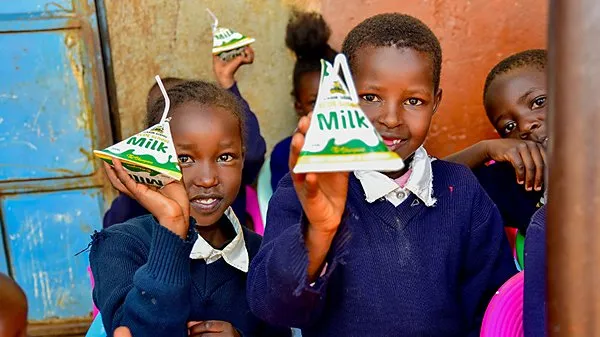 Trabajadores comunitarios recolectan sobres vacíos de alimentos terapéuticos utilizados en programas de nutrición infantil en África.