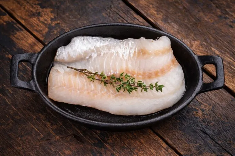 Bacalao bajo en calorías rico en omega 3 en presentación limpia y profesional sobre fondo rústico