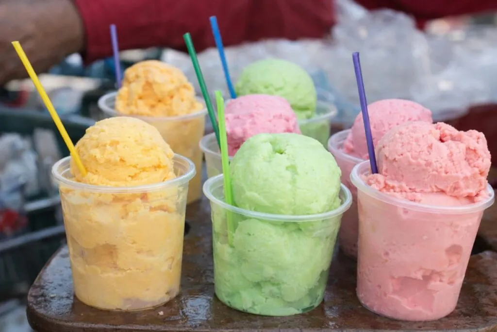 Personas consumiendo comida en vía pública bajo calor en México con opciones frescas y seguras para la nutrición diaria