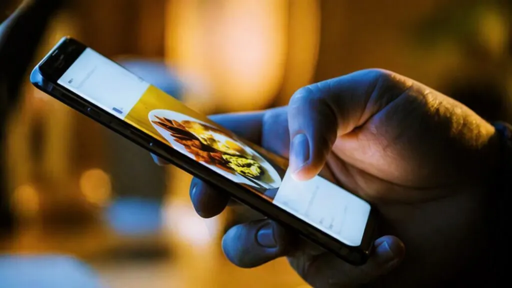 Persona viendo comida en redes sociales para reducir hambre real y controlar antojos