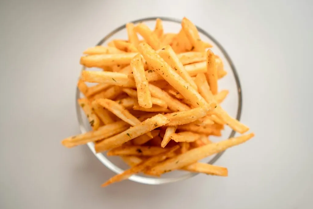 Patatas fritas crujientes y doradas preparadas con técnica de tres frituras y congelación nocturna