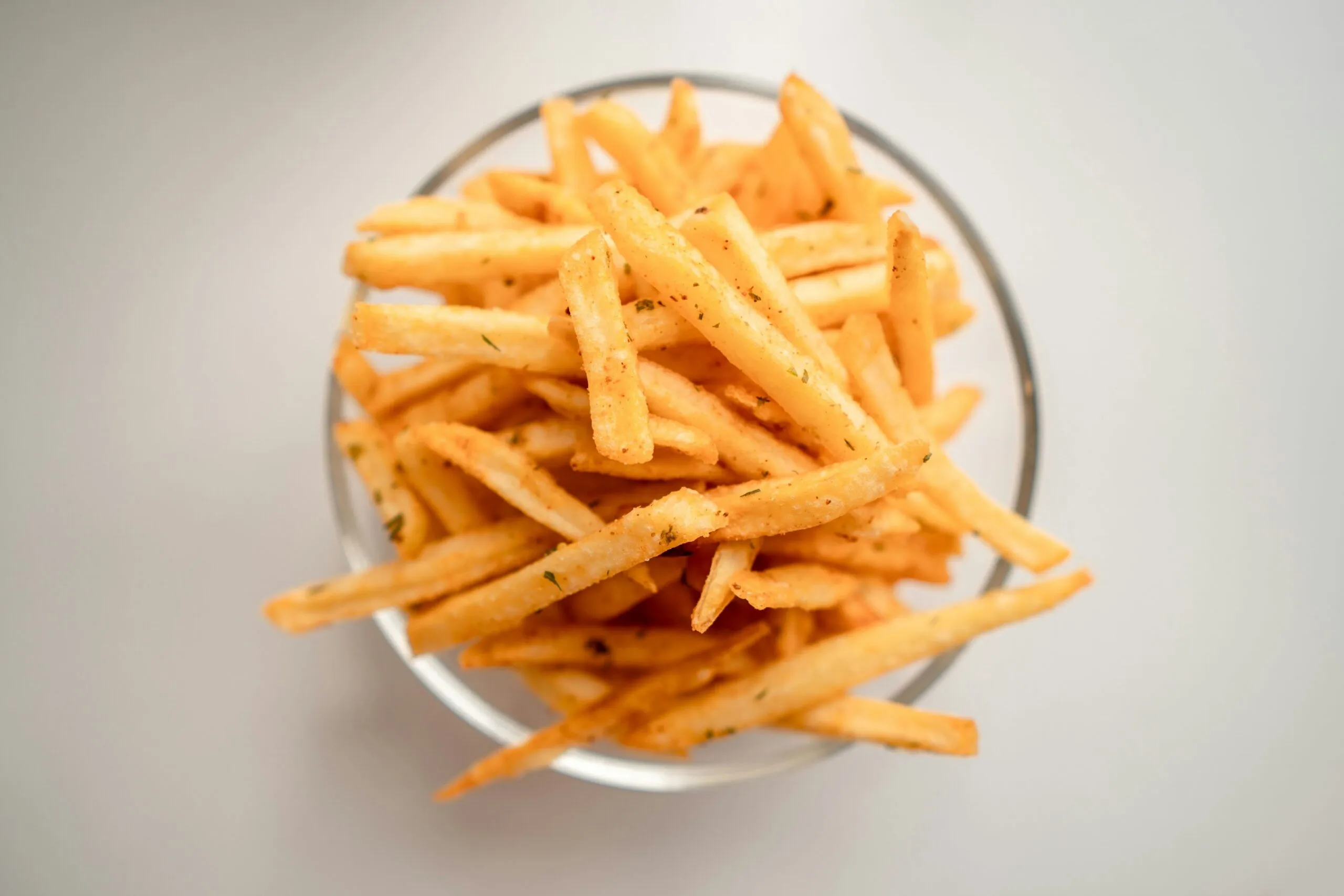 Patatas fritas crujientes y doradas preparadas con técnica de tres frituras y congelación nocturna