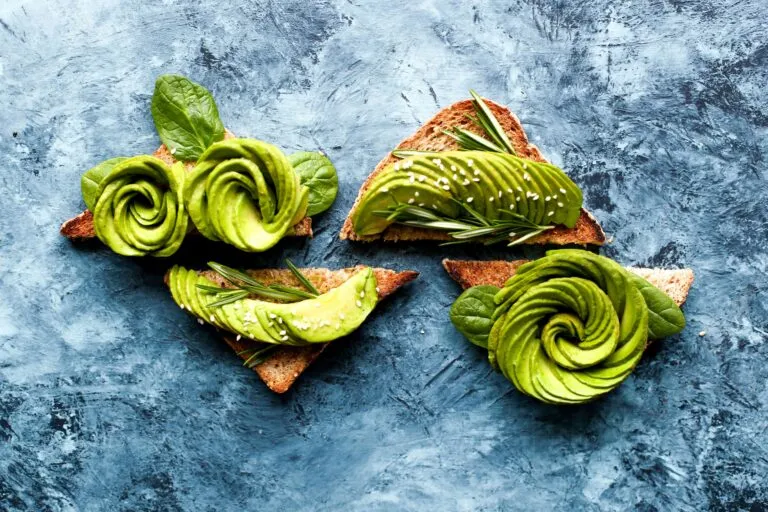 Aguacate fresco partido sobre una tabla de madera, relacionado con los beneficios del aguacate diario para una alimentación saludable.