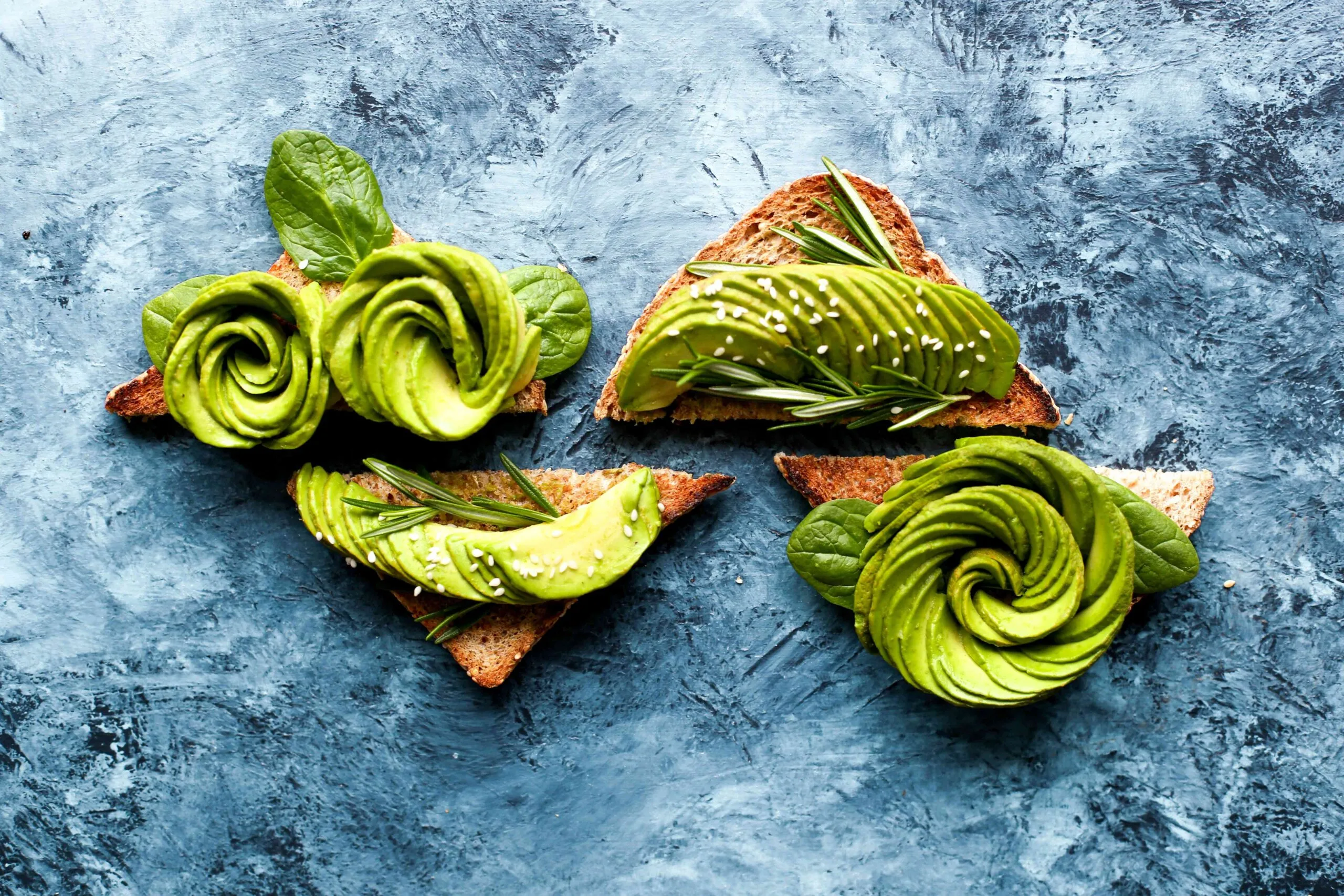 Aguacate fresco partido sobre una tabla de madera, relacionado con los beneficios del aguacate diario para una alimentación saludable.