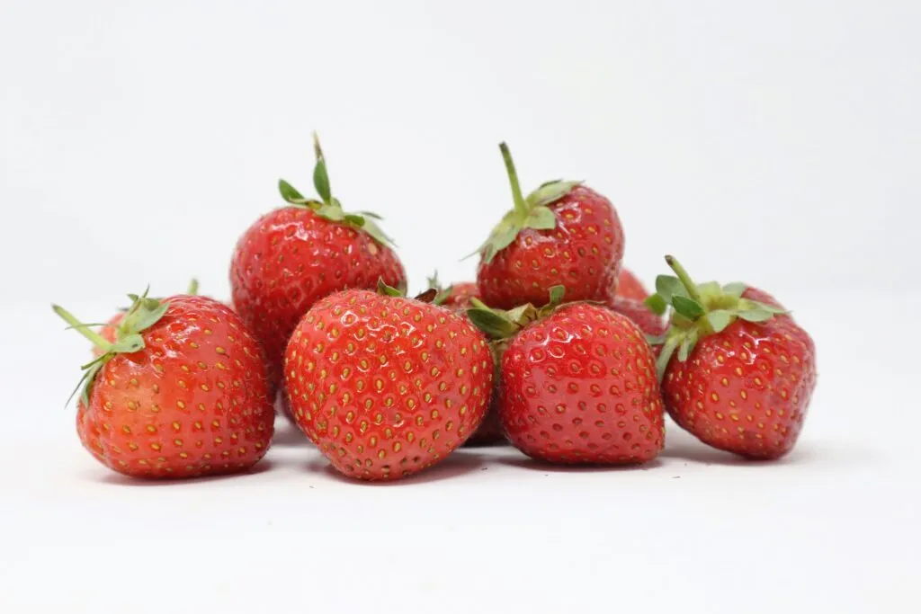 Alimentos para subir las defensas con frutas, verduras, ajo, yogur y frutos secos sobre una mesa de cocina.