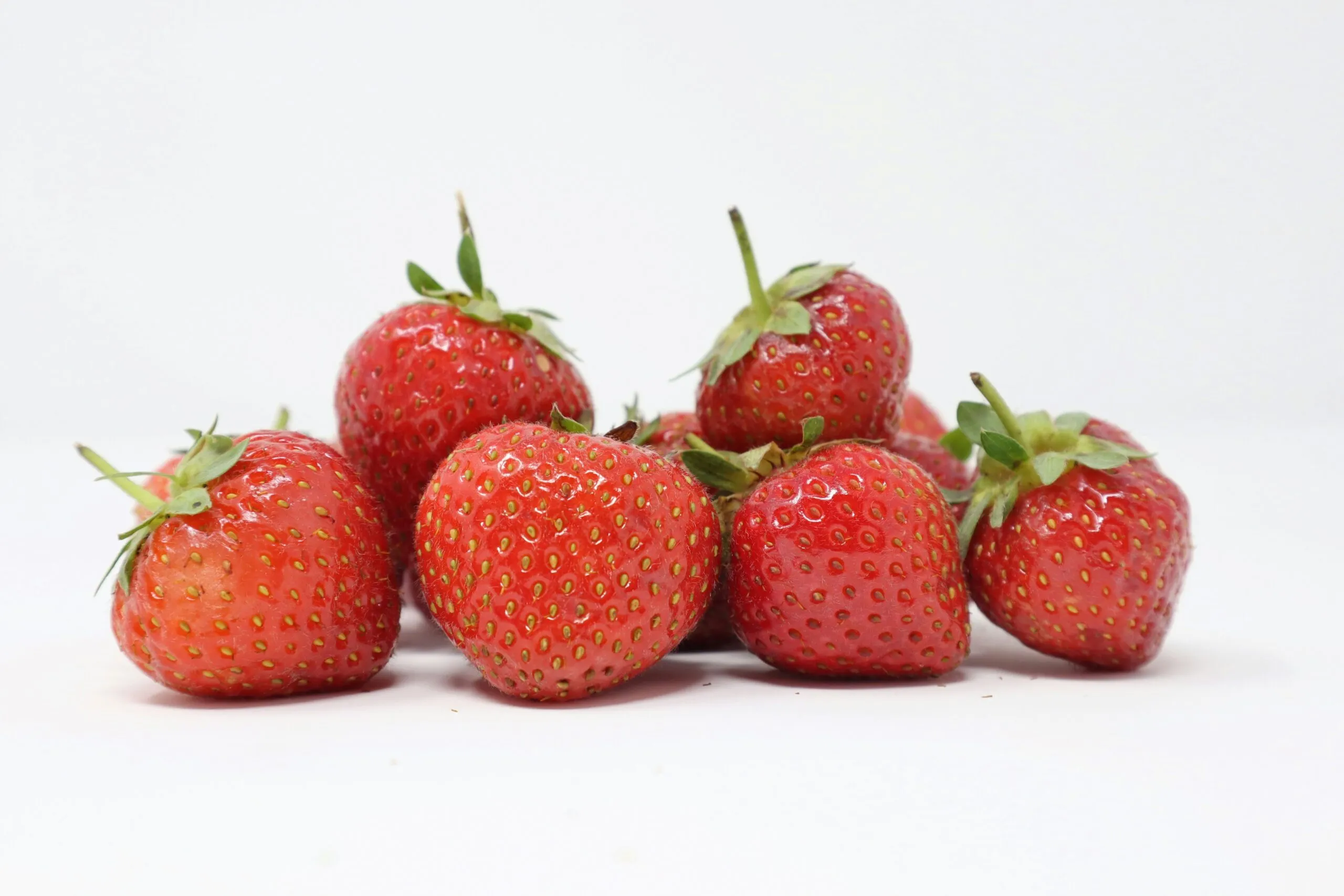 Alimentos para subir las defensas con frutas, verduras, ajo, yogur y frutos secos sobre una mesa de cocina.